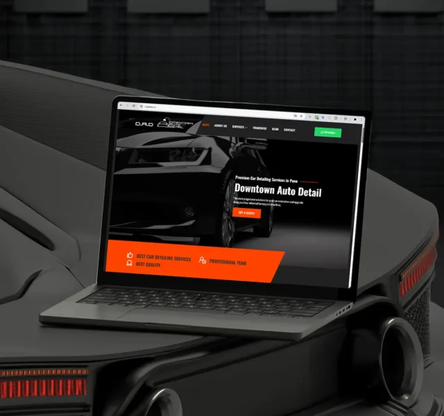 Laptop displaying the Downtown Auto Detail website, a car detailing service in Pune, designed by Thinkster — featuring a sleek black and orange interface with bold typography and a premium automotive aesthetic.