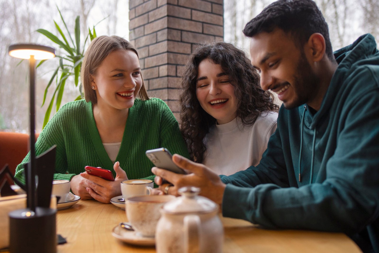 medium-shot-smiley-friends-with-smartphone